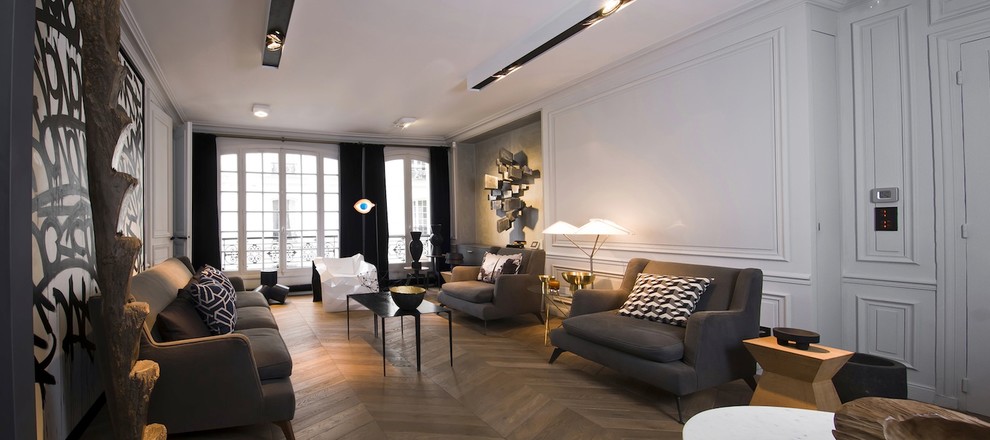 Large contemporary formal enclosed living room in Paris with white walls, medium hardwood floors, no fireplace and no tv.