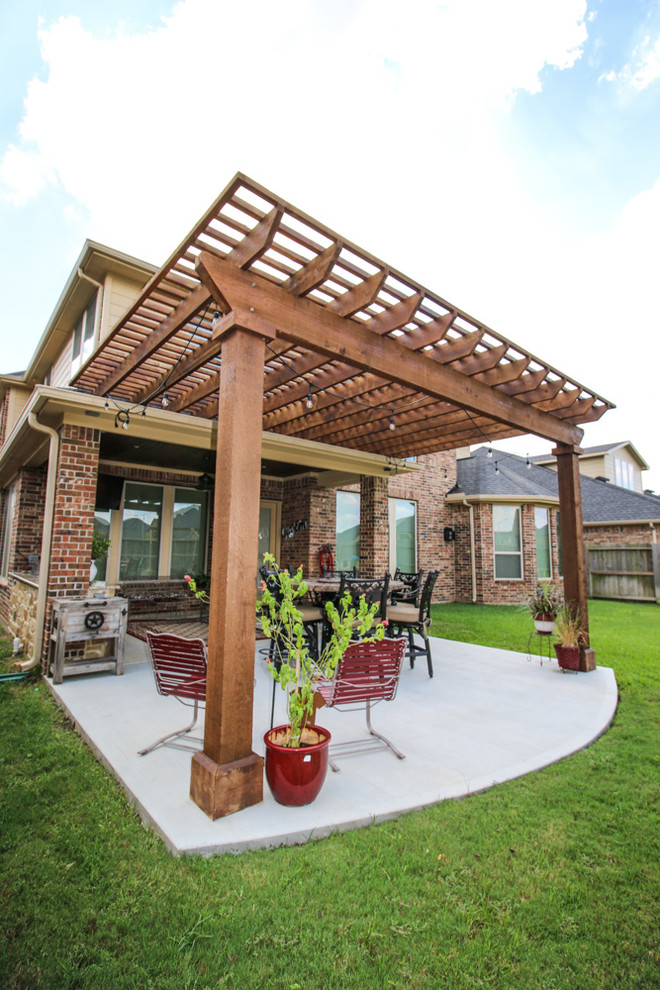 Photo of a mid-sized traditional backyard patio in Houston with concrete slab and a pergola.