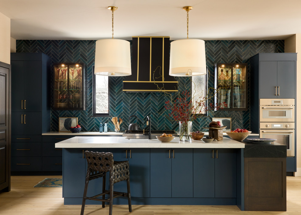 Kitchen - large eclectic galley light wood floor and beige floor kitchen idea in Denver with flat-panel cabinets, blue cabinets, blue backsplash, stainless steel appliances, an island, white countertops, quartz countertops, subway tile backsplash and a farmhouse sink
