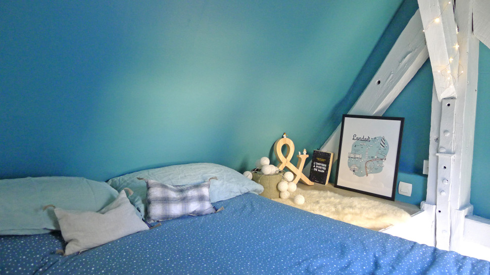 Réalisation d'une petite chambre mansardée ou avec mezzanine bohème avec un mur bleu, un sol en vinyl, aucune cheminée, un sol beige et poutres apparentes.