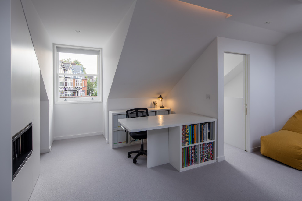 This is an example of a modern study room in Surrey with white walls, carpet, a freestanding desk and grey floor.