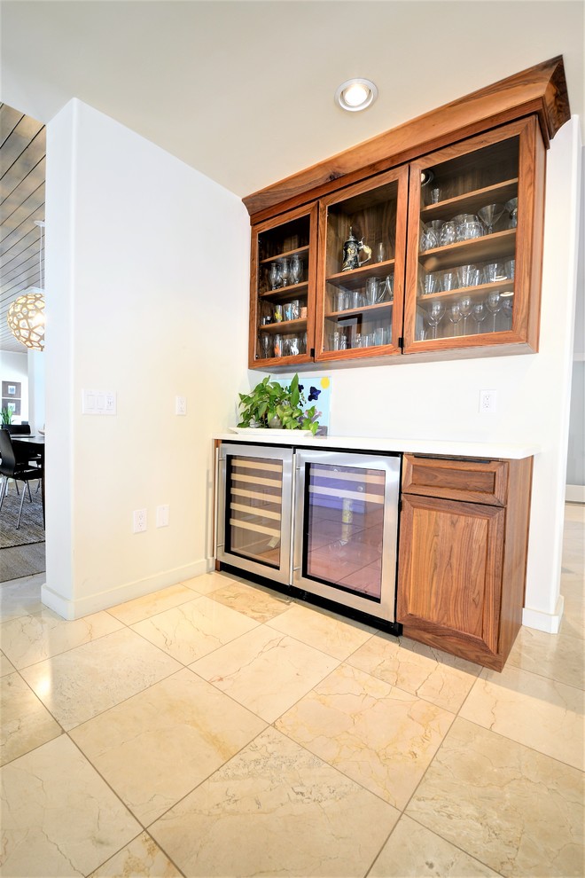 Photo of a mid-sized modern single-wall home bar in Phoenix with shaker cabinets, medium wood cabinets, quartzite benchtops, travertine floors and beige floor.