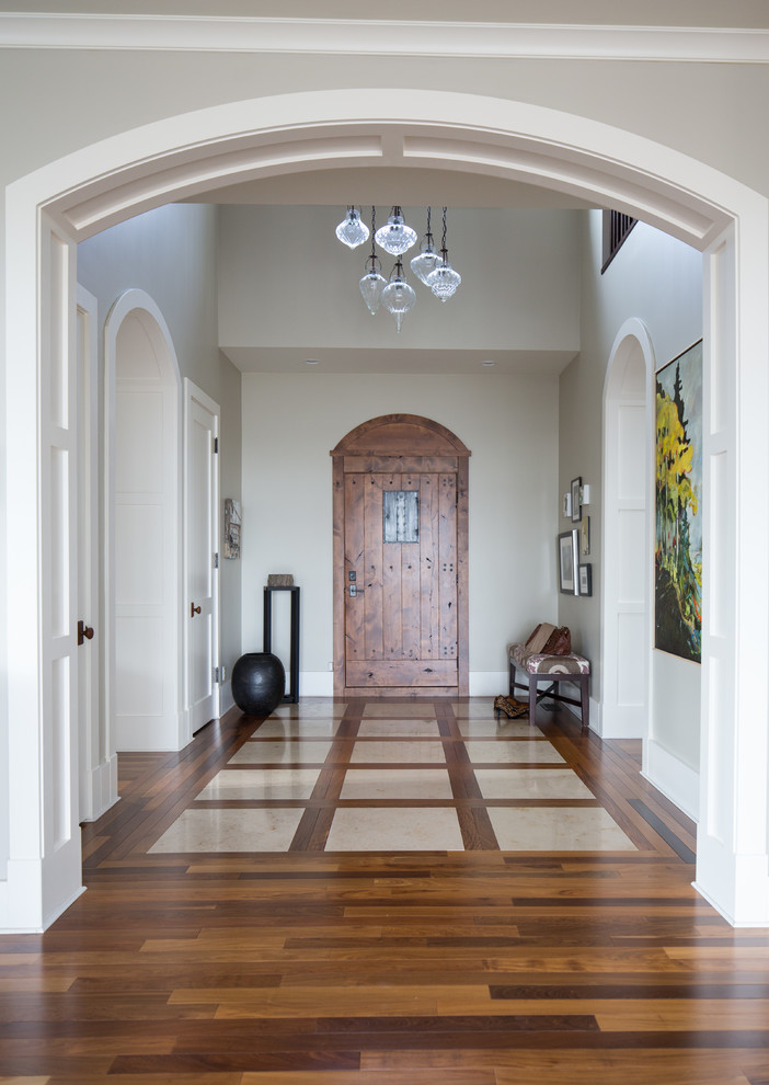 Inspiration for a mid-sized transitional foyer in Calgary with grey walls, dark hardwood floors, a single front door and a dark wood front door.
