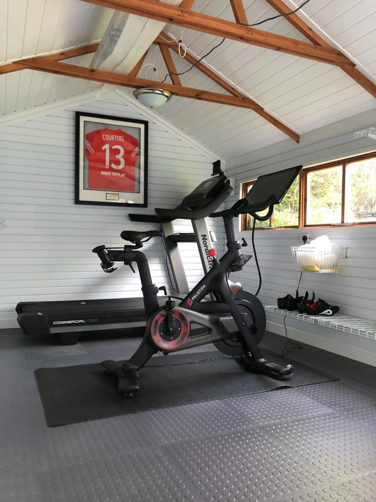 Modern home gym in Berkshire with grey floor and vaulted.
