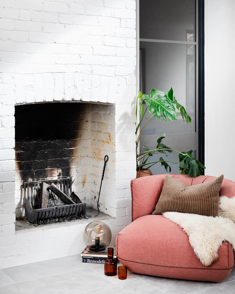 Design ideas for a large contemporary open concept family room in Melbourne with a standard fireplace, a brick fireplace surround and grey floor.