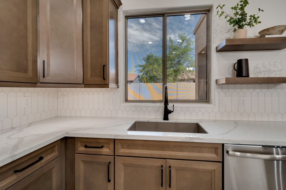 Example of a mid-sized transitional u-shaped ceramic tile and brown floor eat-in kitchen design in Phoenix with beaded inset cabinets, brown cabinets, quartzite countertops, white backsplash, ceramic backsplash, an island and white countertops