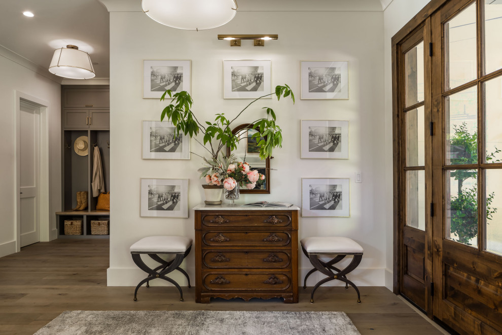 This is an example of a large transitional foyer in San Francisco with white walls, medium hardwood floors, a single front door, a medium wood front door, grey floor and coffered.