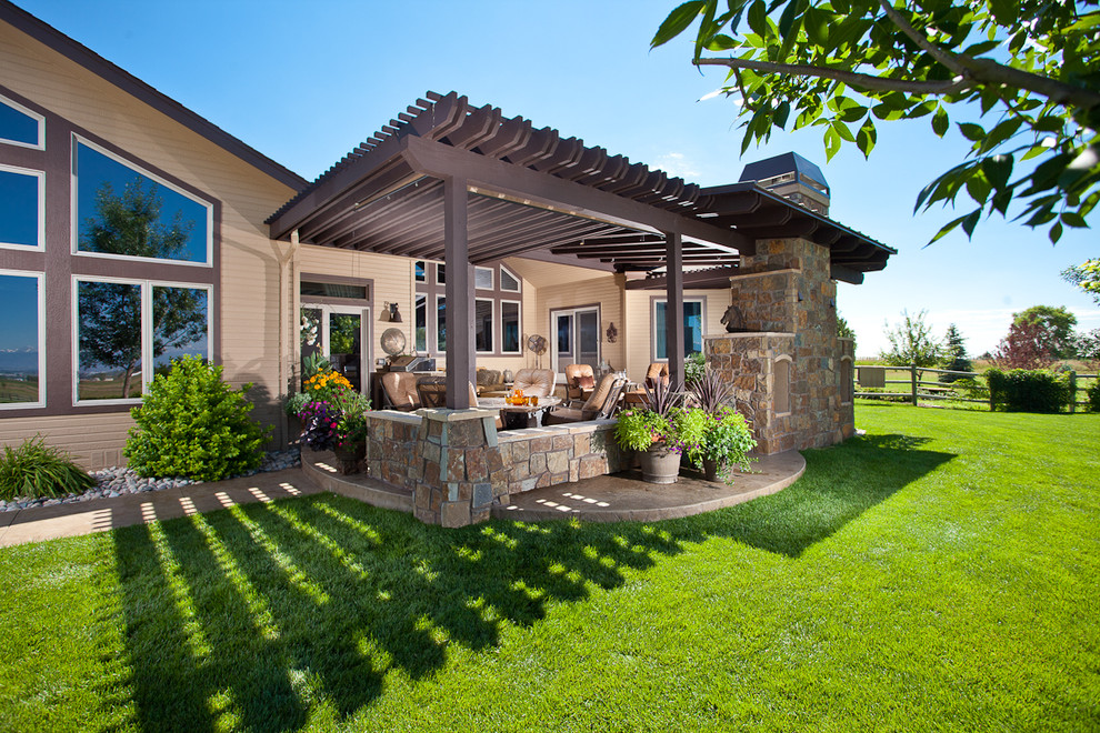 This is an example of a traditional patio in Denver with a fire feature and a pergola.