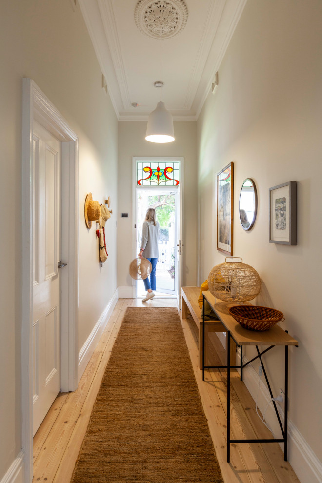 Photo of a large transitional entryway in Perth with white walls and light hardwood floors.