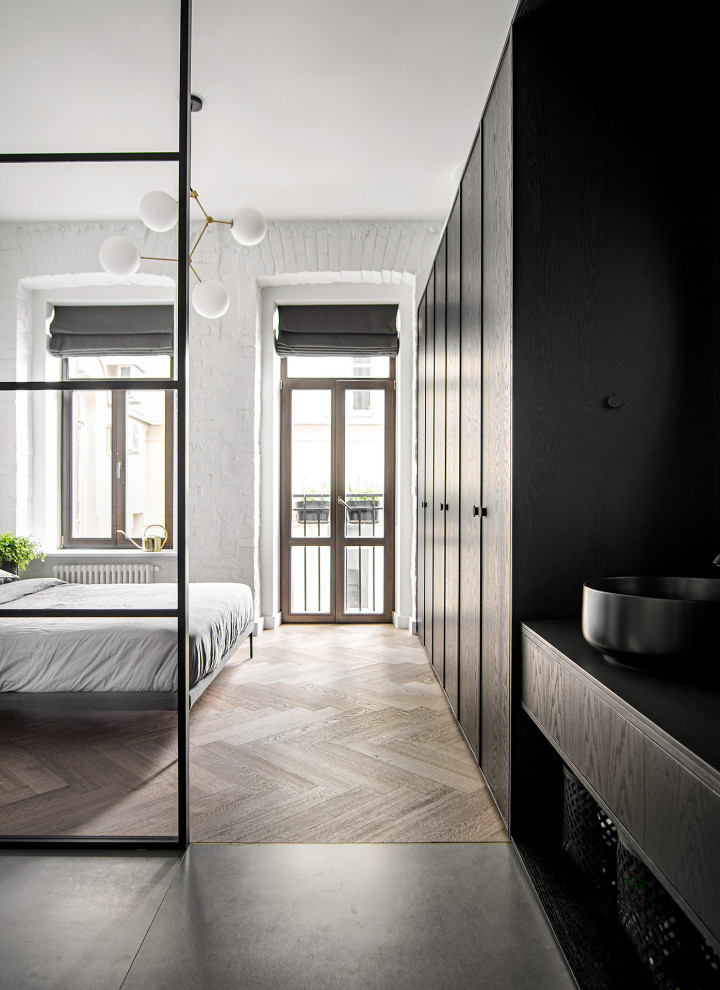 Photo of a contemporary bedroom in Moscow with white walls and light hardwood floors.