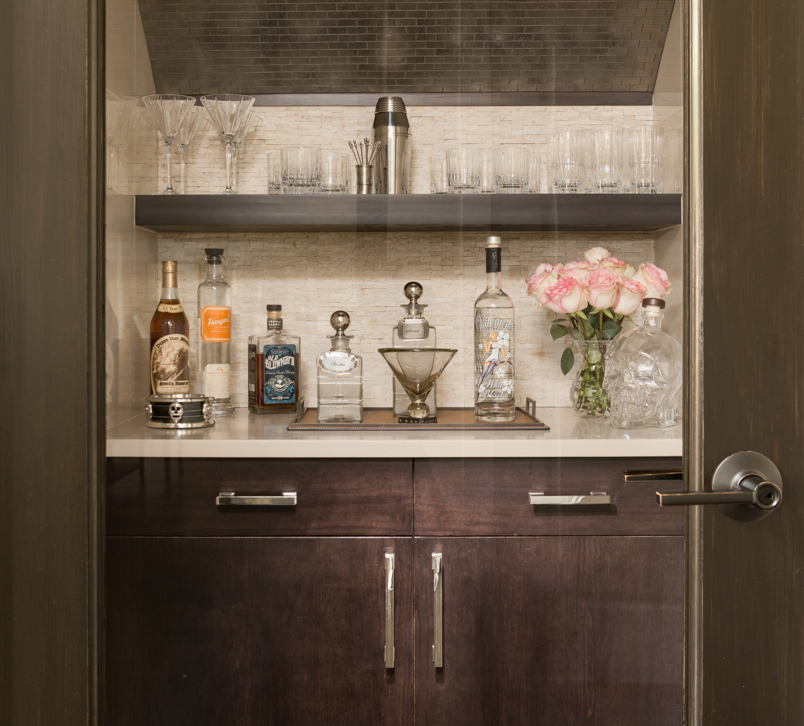 Inspiration for a small contemporary single-wall wet bar remodel in Detroit with dark wood cabinets, quartz countertops, beige backsplash, stone tile backsplash and flat-panel cabinets