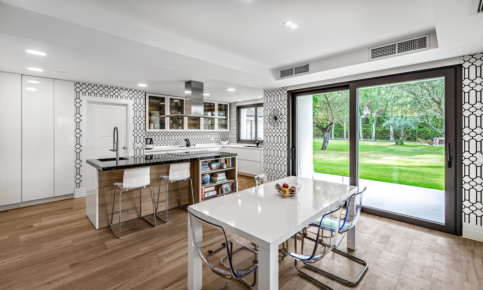 Photo of an expansive contemporary kitchen/dining combo in Madrid with white walls, limestone floors and white floor.