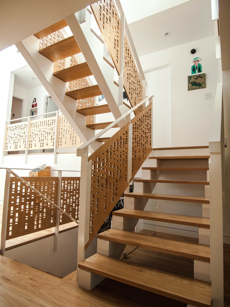 Photo of a contemporary staircase in Portland with open risers and wood railing.