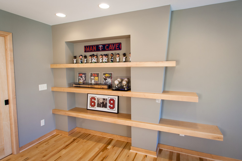 This is an example of a large arts and crafts open concept family room in Minneapolis with a game room, grey walls, light hardwood floors, no fireplace and a built-in media wall.