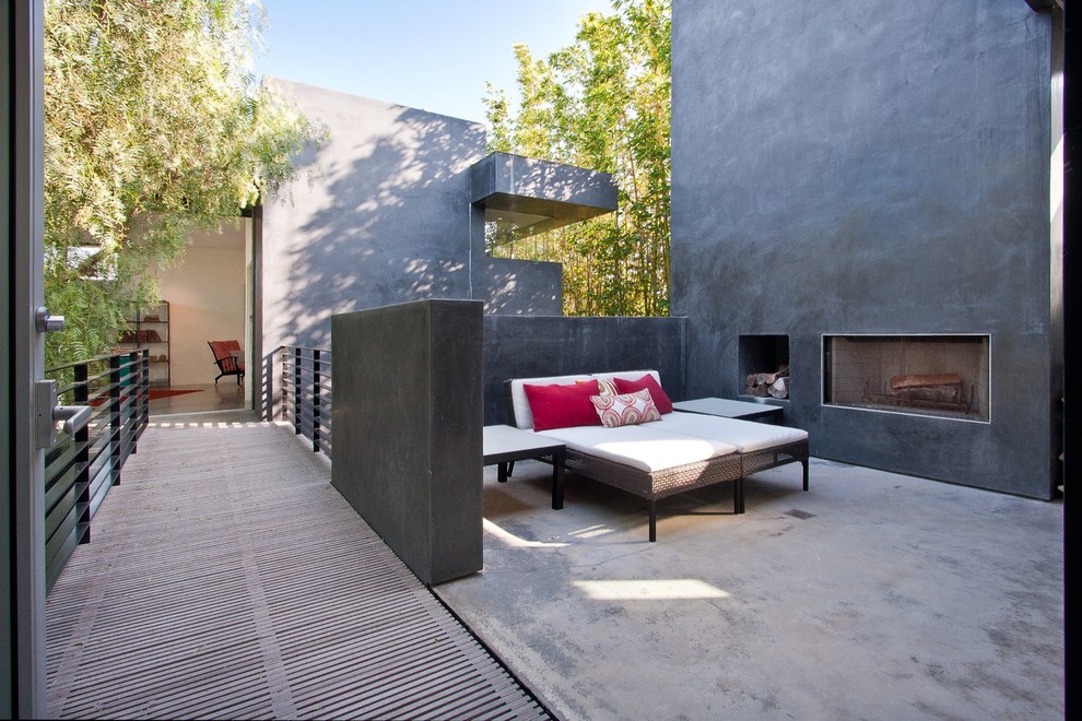 Photo of a large contemporary balcony in Los Angeles with with fireplace, no cover and mixed railing.