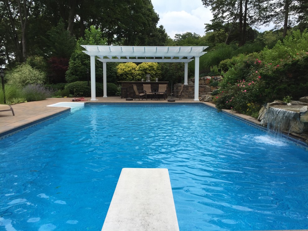 This is an example of a traditional backyard pool in New York with a water feature.