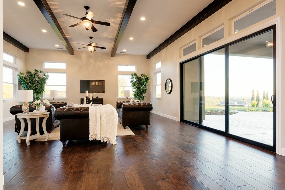 Photo of an expansive arts and crafts enclosed living room in Sacramento with white walls, dark hardwood floors, no fireplace, a wall-mounted tv and brown floor.