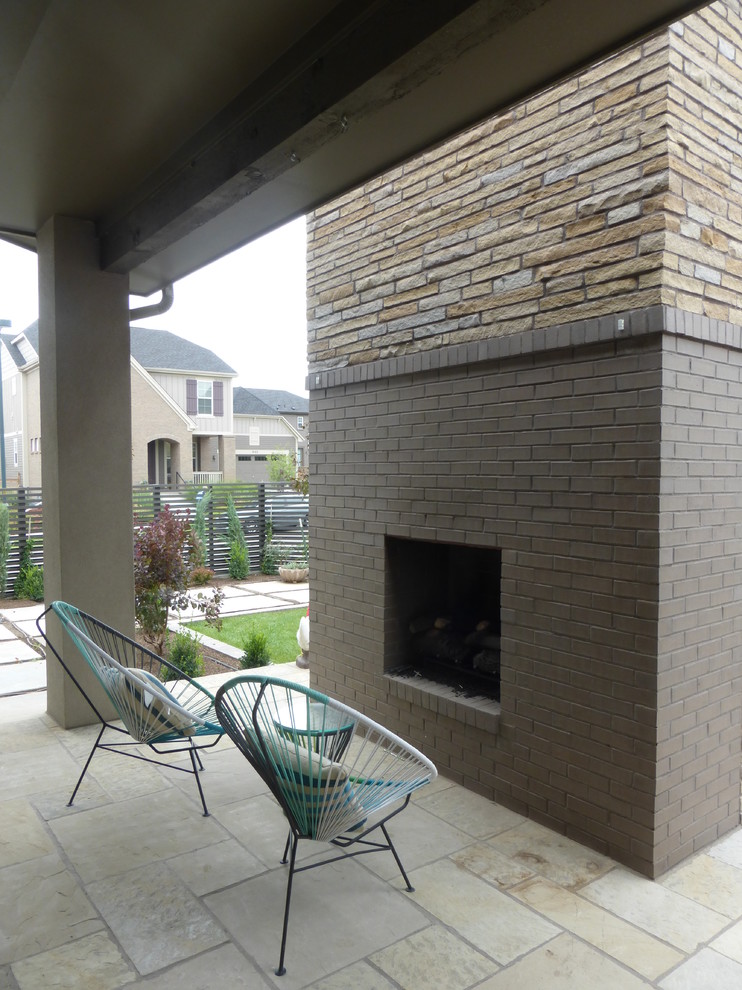 This is an example of a midcentury backyard patio in Denver with with fireplace and natural stone pavers.