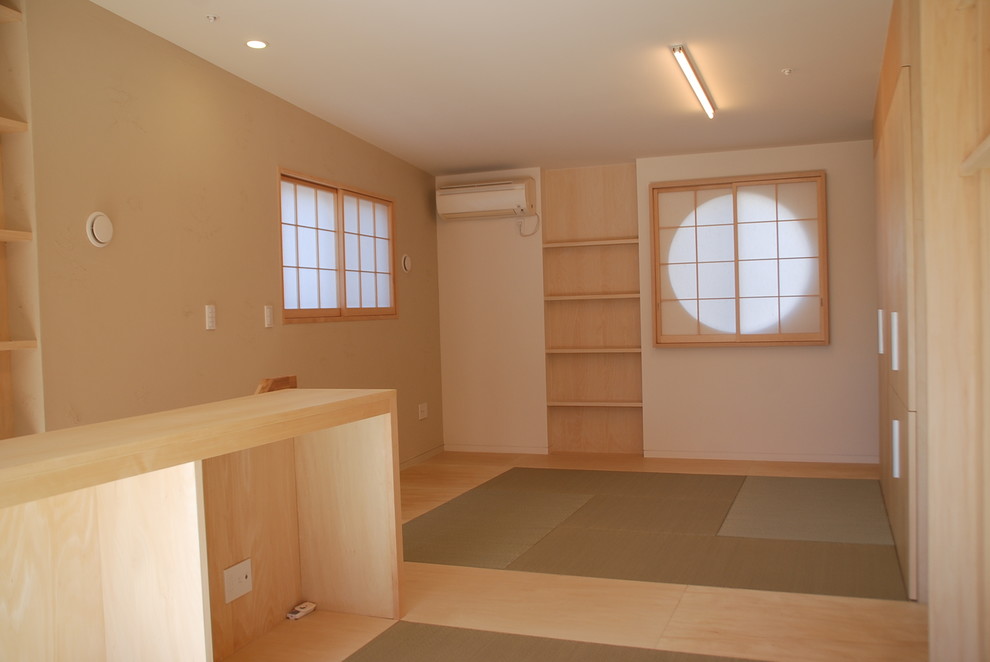 Small asian master bedroom in Tokyo with white walls, tatami floors and beige floor.