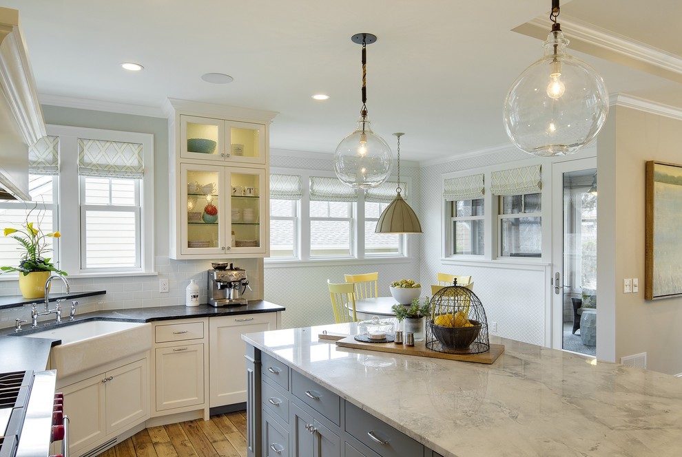 Inspiration for a large country l-shaped eat-in kitchen in Minneapolis with a farmhouse sink, recessed-panel cabinets, white cabinets, marble benchtops, white splashback, ceramic splashback, panelled appliances, medium hardwood floors and with island.