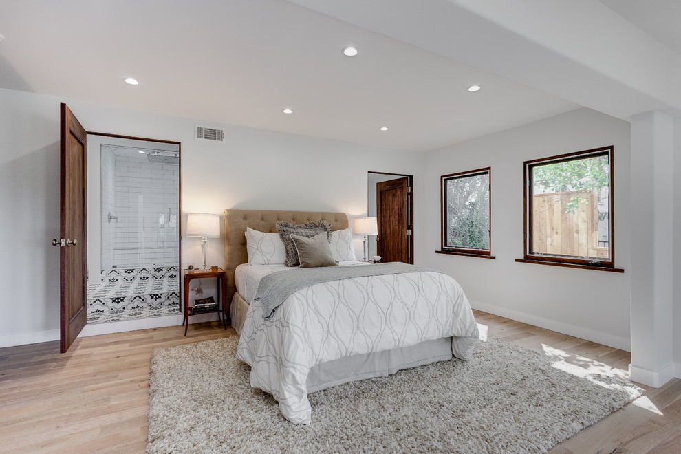 Photo of a large mediterranean master bedroom in Los Angeles with white walls, light hardwood floors and no fireplace.