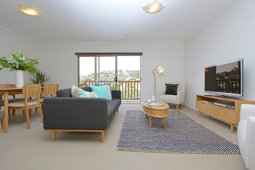 This is an example of a large contemporary living room in Hobart with carpet, no fireplace, a freestanding tv and white walls.
