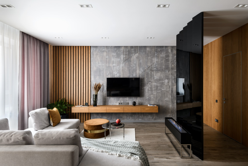 Пример оригинального дизайна: открытая гостиная комната среднего размера в современном стиле с серыми стенами, полом из керамогранита, горизонтальным камином, фасадом камина из металла, телевизором на стене, коричневым полом и ковром на полу