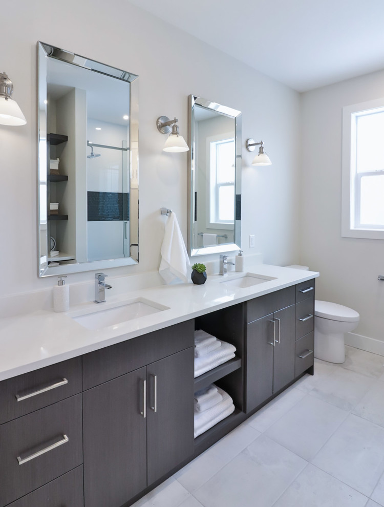 Drop-in bathtub - large transitional master white tile and porcelain tile porcelain tile and gray floor drop-in bathtub idea with flat-panel cabinets, gray cabinets, a one-piece toilet, gray walls, an undermount sink and quartz countertops