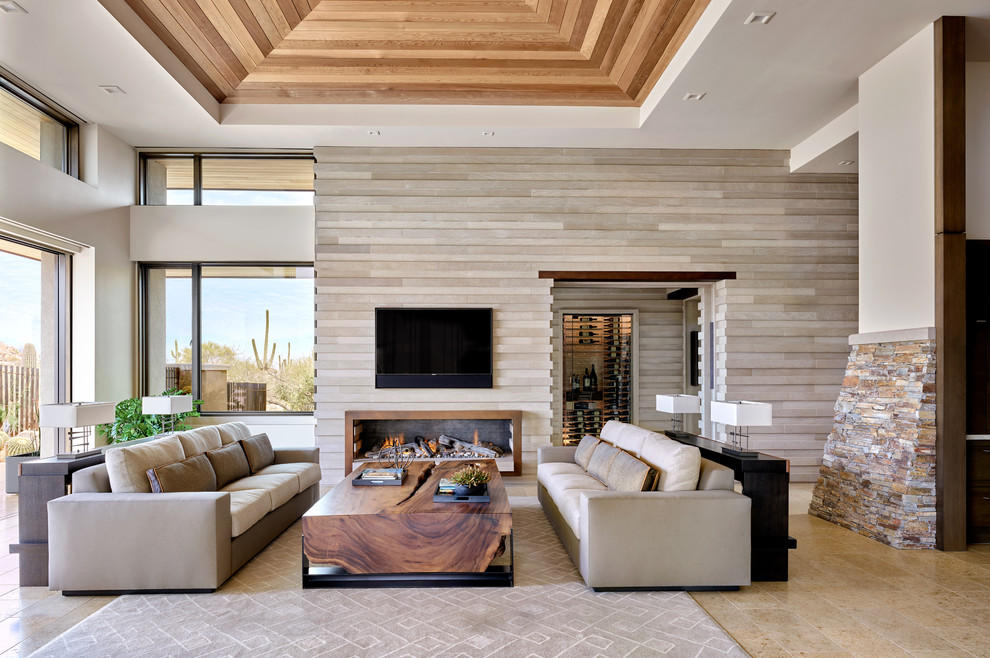 Photo of an open concept family room in Phoenix with beige walls, a ribbon fireplace, a metal fireplace surround, a wall-mounted tv and beige floor.