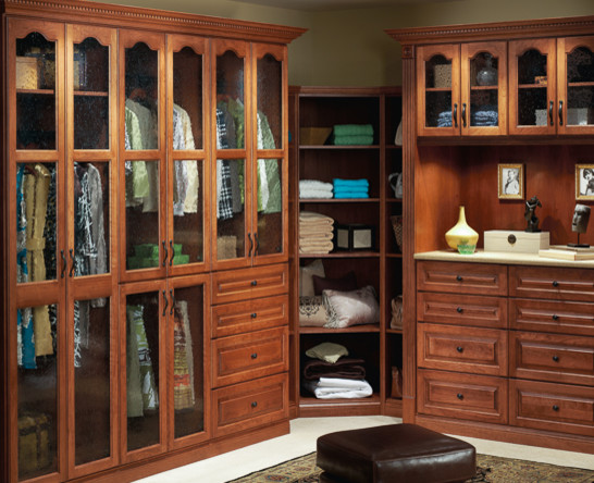 Photo of a mid-sized transitional gender-neutral walk-in wardrobe in Jacksonville with raised-panel cabinets, dark wood cabinets, carpet and beige floor.