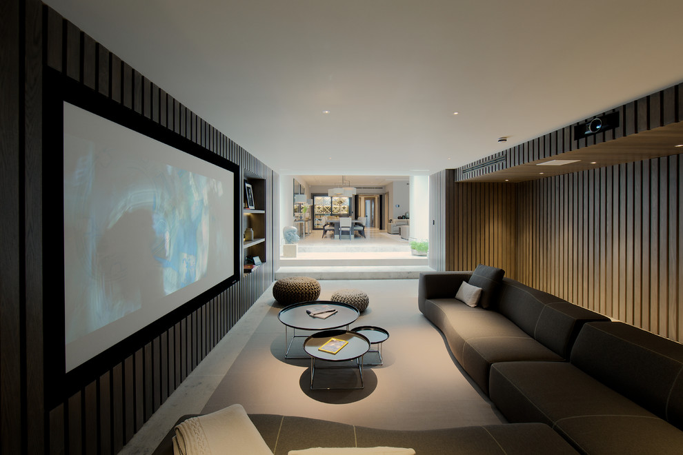This is an example of a large contemporary enclosed home theatre in London with brown walls, limestone floors, a projector screen and beige floor.