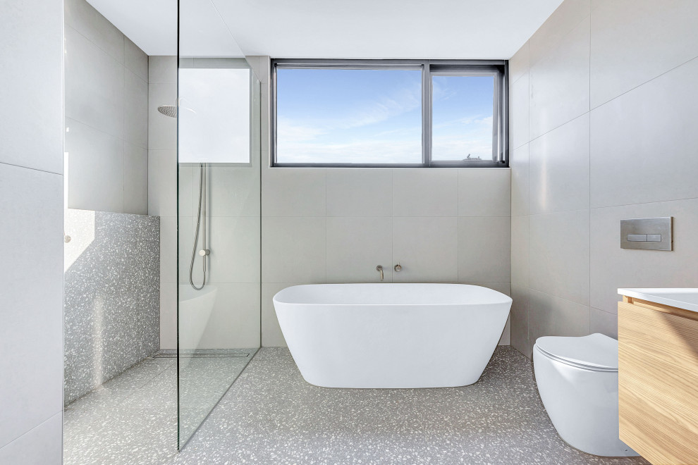 Design ideas for a mid-sized contemporary master bathroom in Melbourne with light wood cabinets, a freestanding tub, an open shower, gray tile, porcelain tile, porcelain floors, an undermount sink, engineered quartz benchtops, white benchtops, a double vanity and a floating vanity.