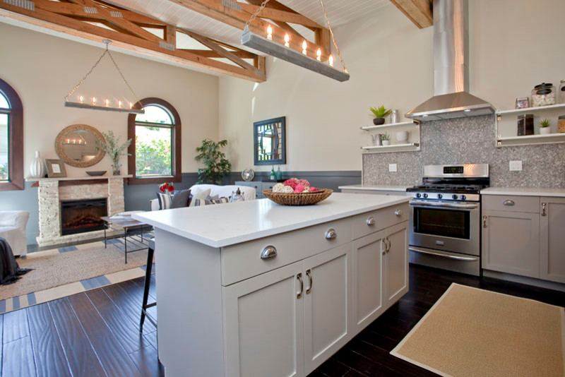 Inspiration for a small country l-shaped open plan kitchen in San Francisco with a farmhouse sink, shaker cabinets, grey cabinets, quartz benchtops, grey splashback, stone tile splashback, stainless steel appliances, with island, dark hardwood floors and brown floor.