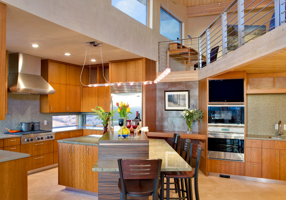Design ideas for an expansive modern u-shaped eat-in kitchen in Albuquerque with an integrated sink, flat-panel cabinets, medium wood cabinets, granite benchtops, metallic splashback, glass tile splashback, stainless steel appliances, travertine floors and with island.