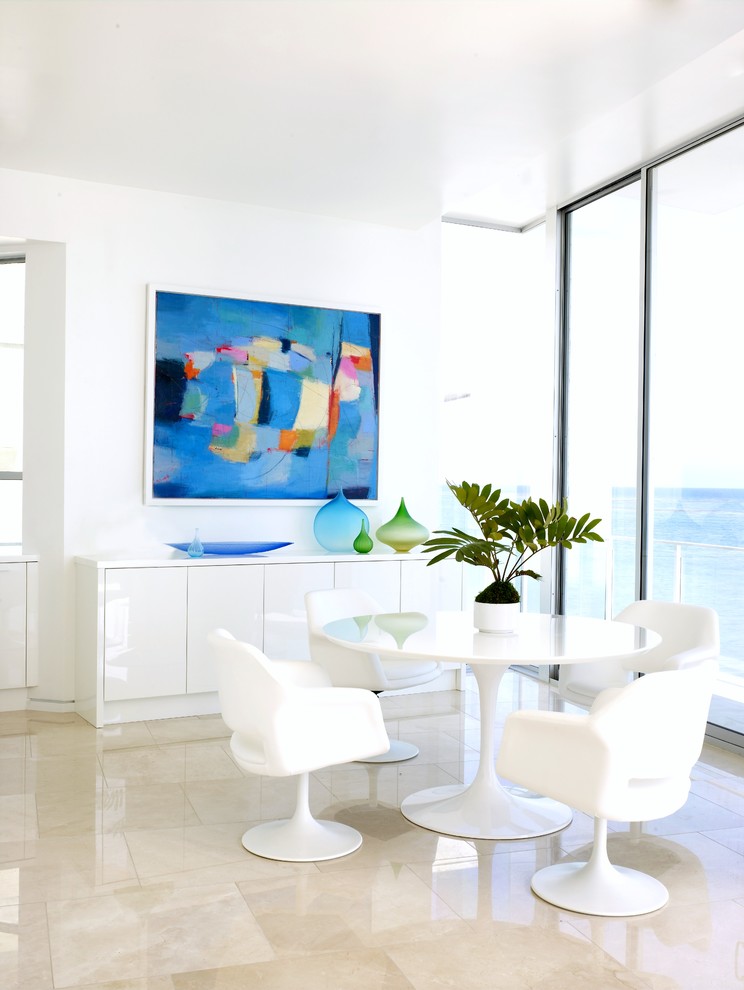 Inspiration for a beach style dining room in Los Angeles with white walls and beige floor.