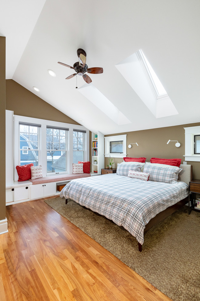 This is an example of an arts and crafts master bedroom in Detroit with light hardwood floors and vaulted.