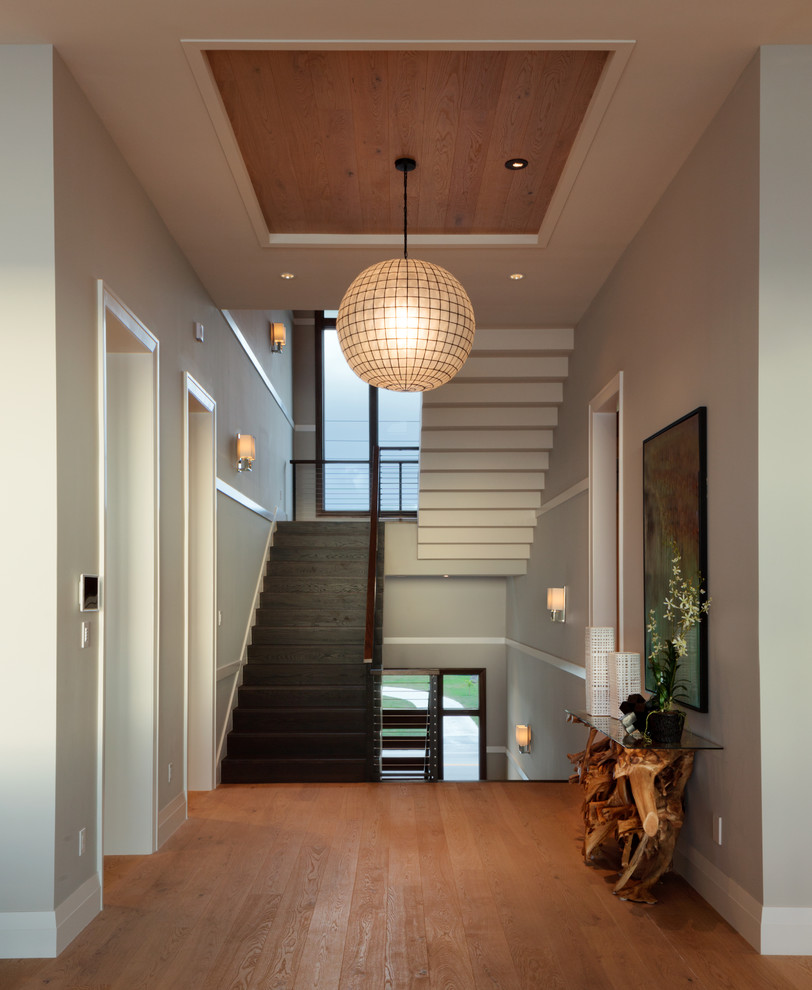 Staircase - large transitional wooden u-shaped cable railing staircase idea in Miami with wooden risers