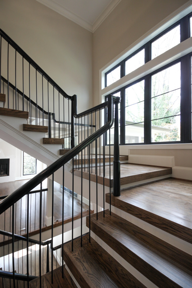 Exemple d'un très grand escalier éclectique en U avec des marches en bois, des contremarches en bois et un garde-corps en matériaux mixtes.