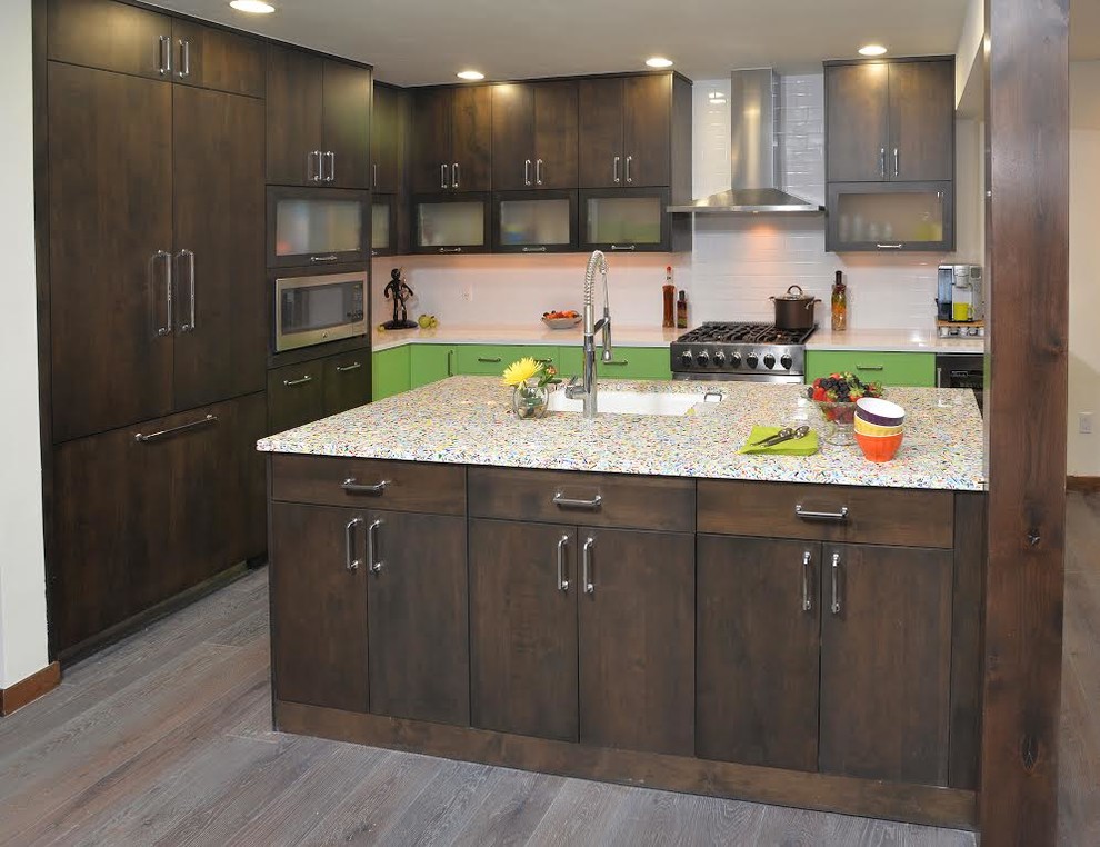 This is an example of a mid-sized l-shaped separate kitchen in Denver with an undermount sink, flat-panel cabinets, dark wood cabinets, limestone benchtops, white splashback, ceramic splashback, stainless steel appliances, painted wood floors and a peninsula.