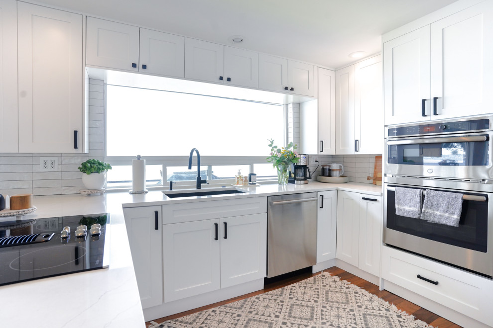 Small modern u-shaped eat-in kitchen in Seattle with an undermount sink, white cabinets, granite benchtops, white splashback, ceramic splashback, stainless steel appliances, with island and white benchtop.