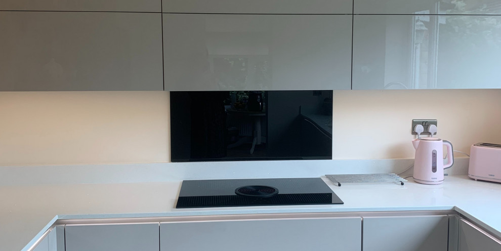 Large modern l-shaped separate kitchen in Other with an integrated sink, white cabinets, quartzite benchtops, black splashback, glass sheet splashback, coloured appliances, no island and yellow benchtop.