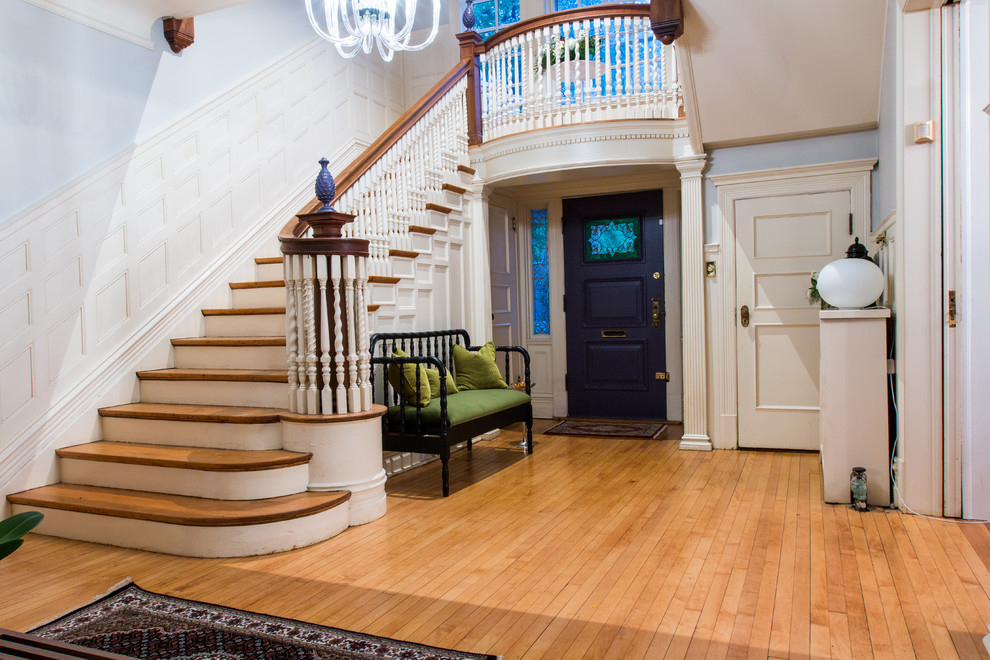 This is an example of a mid-sized eclectic foyer in St Louis with grey walls, light hardwood floors, a single front door and a purple front door.