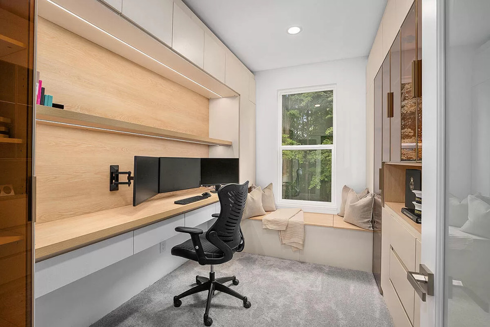 This is an example of a small modern study room in Grand Rapids with carpet and a built-in desk.