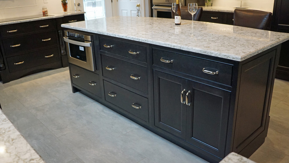 Inspiration for a large transitional u-shaped eat-in kitchen in Boston with an undermount sink, beaded inset cabinets, black cabinets, quartz benchtops, white splashback, subway tile splashback, stainless steel appliances, porcelain floors and with island.