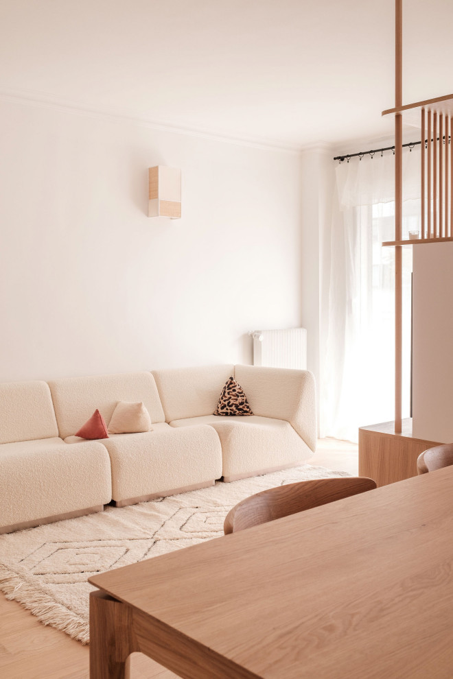 Esempio di un soggiorno minimal di medie dimensioni e aperto con libreria, pareti bianche, pavimento in legno massello medio e TV a parete