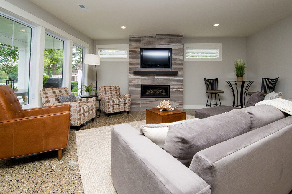 Design ideas for a mid-sized transitional open concept living room in Grand Rapids with grey walls, concrete floors, a standard fireplace, a tile fireplace surround, grey floor and a built-in media wall.