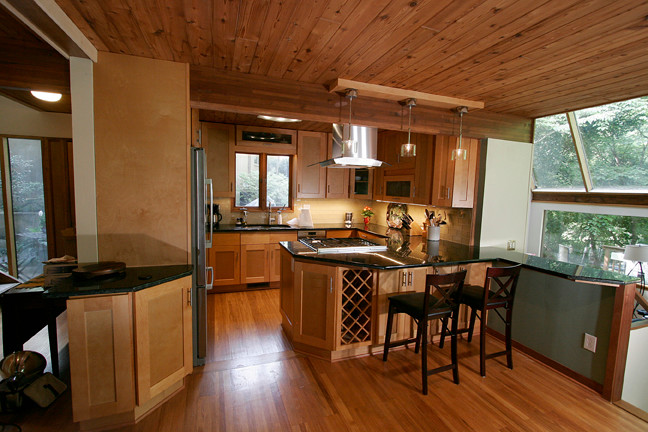 Example of a small transitional l-shaped porcelain tile eat-in kitchen design with shaker cabinets, light wood cabinets, granite countertops, beige backsplash, glass tile backsplash, stainless steel appliances and a peninsula