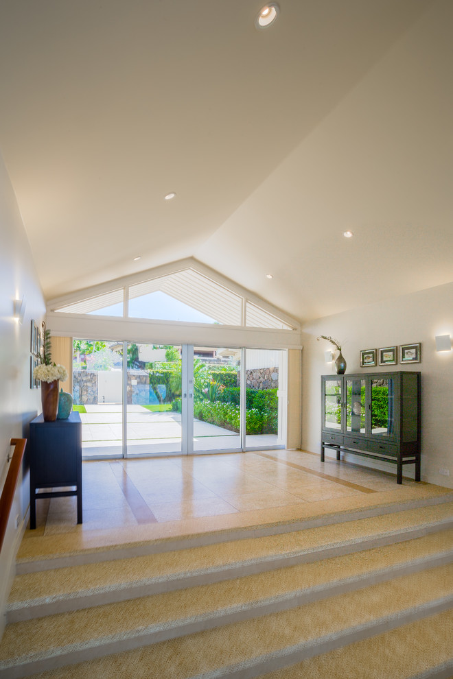 Design ideas for a large contemporary entry hall in Hawaii with white walls, porcelain floors, a sliding front door, a glass front door and beige floor.