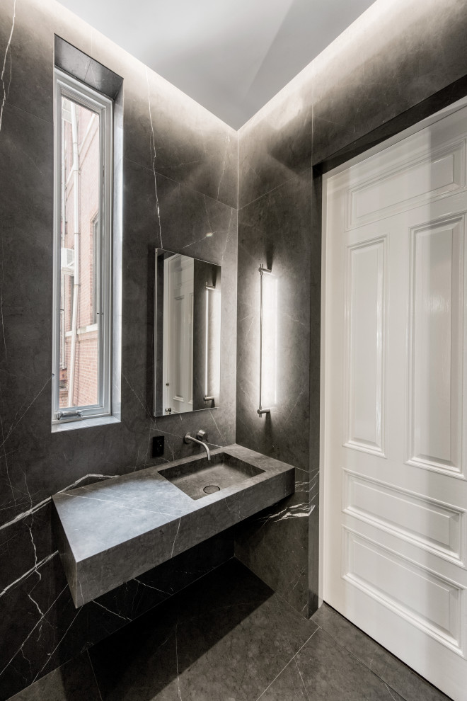 This is an example of a small modern 3/4 bathroom in New York with grey cabinets, an open shower, gray tile, stone slab, grey walls, marble floors, a wall-mount sink, marble benchtops, grey floor, an open shower and grey benchtops.