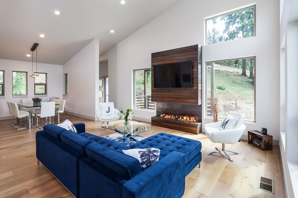 This is an example of a large contemporary open concept living room in Other with white walls, medium hardwood floors, a ribbon fireplace and a wall-mounted tv.